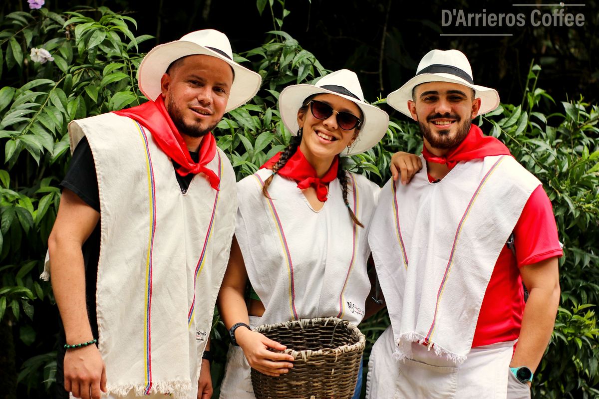 Tres visitantes con poncho, sombrero, pañuelo rojo y canasto